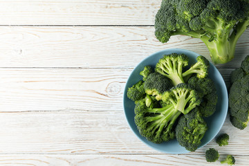 Plate with broccoli on wooden background, top view. Healthy food