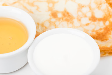 Part of breakfast with pancakes and sour cream.