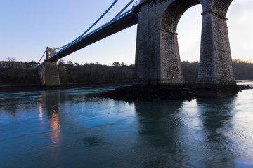 Naklejka premium Night view of the illuminated Menai Suspension Bridge spanning the Menai Strait, Isle of Anglesey, North Wales