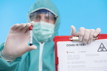 Doctor holding test tube with Positive Coronavirus or Covid-19 test blood sample - Concept of...