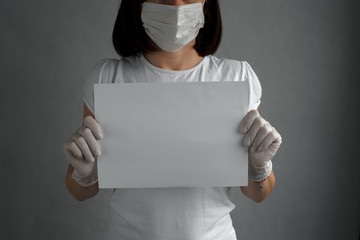 Women doctor with white paper against coronavirus. White clothes. Copy space