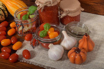 cocktail tomatoes, garlic, spices, colorful pumpkins and scattered kitchen salt, mortar for the winter