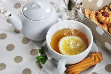 various cookies and biscuits baked at home in a container and tea in a retro cup with free space for text