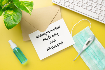 I Stay Home for hashtag, pandemic coronavirus prevention campaign concept. Mockup letter paper with facial masks on yellow home office table. #IStayHomeFor