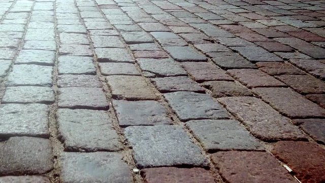 ancient cobblestone street, close-up of rectangular various colors of granite bricks