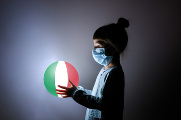 little cute girl in medical mask holding a luminous planet Earth in her hands. Coronavirus in Italy. covid-19 concept.