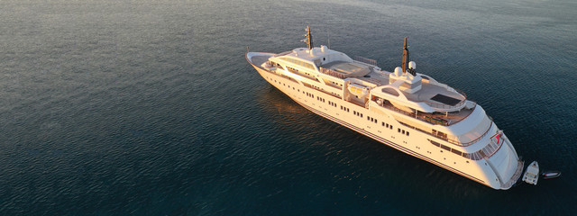 Aerial drone top down photo of luxury yacht with wooden deck anchored in open ocean sea