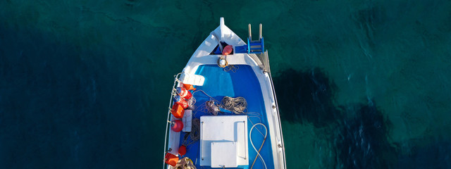 Aerial drone ultra wide top down photo of traditional wooden fishing boat near crystal clear sea of...
