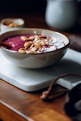 Purple berry smoothie with coconut flakes, oats and almond nuts.