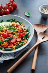 Fresh healthy salad with chickpea, avocado, cherry tomatoes and spinach.