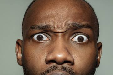 Shocked. Close up of face of beautiful african-american young man, focus on eyes. Human emotions, facial expression, cosmetology, body and skin care concept. Well kept skin. Wellbeing.