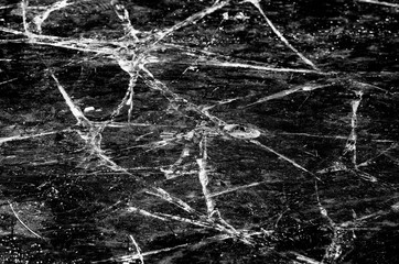 Natural pattern of cracks on the ice cover of the river in black and white style