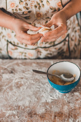 Woman hands dumplings with potatoes on a white background, traditional Ukrainian food.