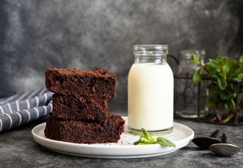 Brownie chocolate cake with milk on the kitchen table. Dessert.