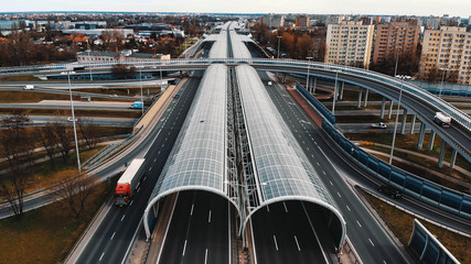 Warsaw, Poland, 03.20.2020. - The anti-noise glass tunnel and overpass Trasa Torunska highway in...