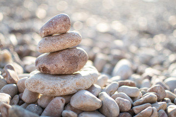  Zen pyramid from spa stones on a blurred sea background. Sea stones on the coast. Sea coast. Place for text. Sea view. A stone structure on the beach