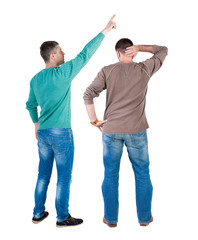 Fototapeta premium Back view of two man in sweater pointing.