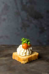 tasty canapes with cheese on a small skewer on a gray background. Vertical frame