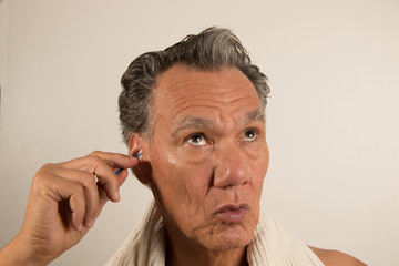 Obraz premium Man Cleaning his Ear with a Cotton Tip Swab 