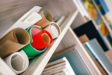 paintings and rolls of paper lie on the artist’s shelf