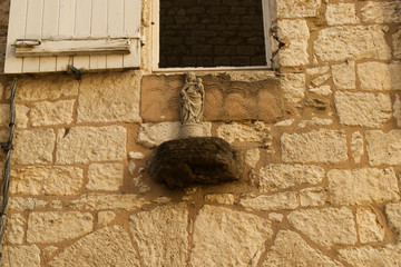 Une statue religieuse sur un mur de maison à Montflanquin village du département du Lot et...