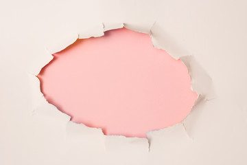 agujero en papel blanco con fondo rosa