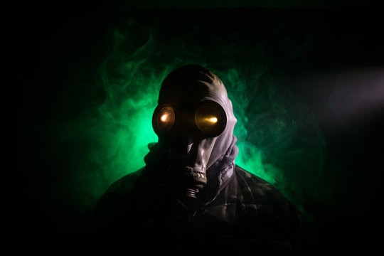 Gas mask with clouds of smoke on a dark background. Sign of radioactive contamination. Means for radiation protection. Danger of carbon monoxide poisoning.