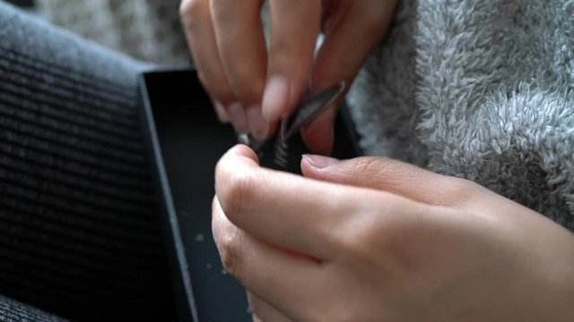 slow motion the woman is cutting her nails with small scissors