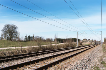 Fototapeta na wymiar Double electrified railroad tracks in early spring going from left to right