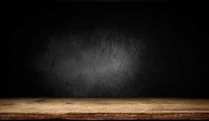 Selected focus empty brown wooden table and wall texture or old black brick wall blur background...