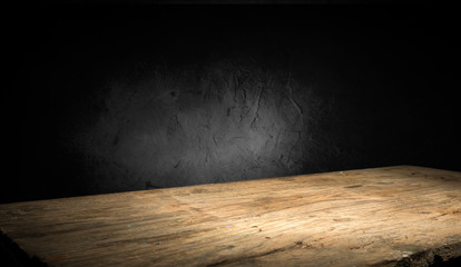 Selected focus empty brown wooden table and wall texture or old black brick wall blur background...