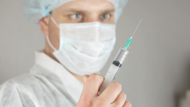 Close up of medical professional in white coat holding syringe before injection. Concept of vaccination, immunization and preventive healthcare, highlighting safety, precision and modern standarts