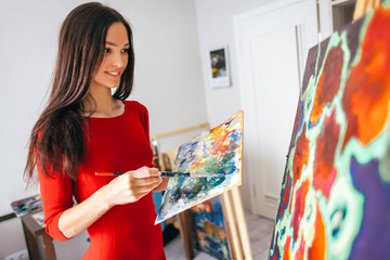 girl with long hair draws an oil painting