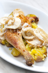 chicken leg on creamy onion sauce with potatoes