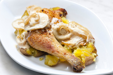 chicken leg on creamy onion sauce with potatoes