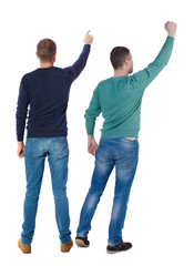 Back view of two man in sweater pointing.