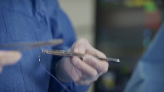 Close up on surgeon hand while stiching. change focus to heart monitor