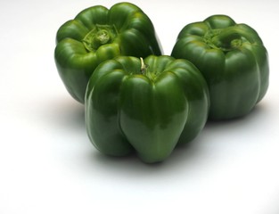 Three green peppers on a white background.