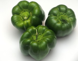 Three green peppers on a white background.