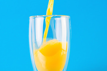 Glass of orange juice on a blue background