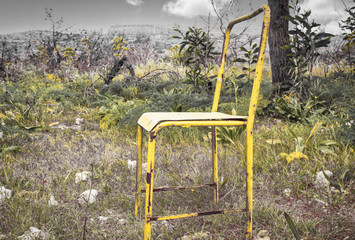 old yellow chair stands in the autumn park. concept world lock down