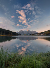 Fototapeta na wymiar Lago di Misurina in Dolomites, Scenic morning landscape. Amazing panorama view with mountains and cloudy sky reflection in lake.