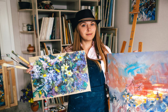 Girl artist holds his paintings in his hands