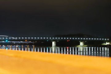 view across the danube to the lighted bridge at night