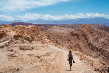 Fototapeta na wymiar Traveller hiking at the Moon Valley (Spanish: Valley de la Luna ) in the Atacama Desert, northern Chile, South America.