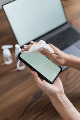 Woman disinfect smartphone screen wiping antibacterial sanitizer del on display