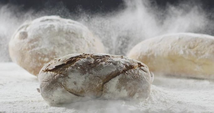 Bakery and cooking concept. Fresh bread with a splash falls into flour