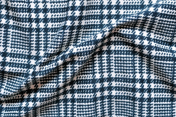 Dense black-and-white checkered fabric. Folds.