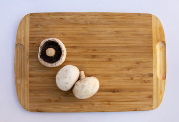 mushrooms champignons on a wooden board