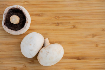 mushrooms champignons on a wooden board